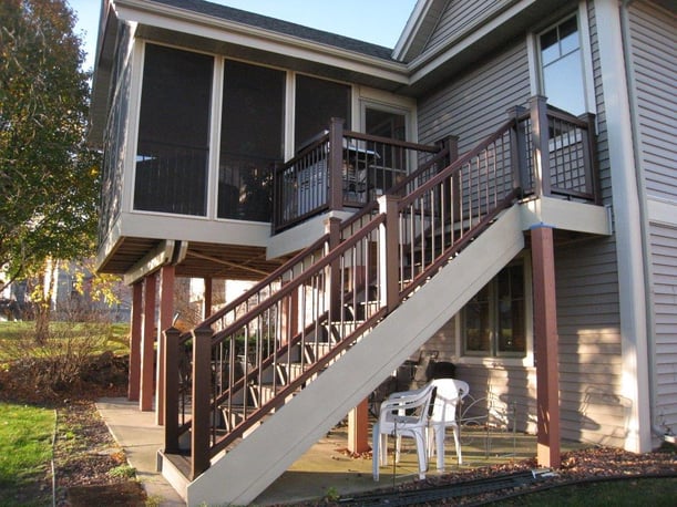 An exterior shot of the outside of a three season porch and smaller uncovered porch with stairs leading up to both.